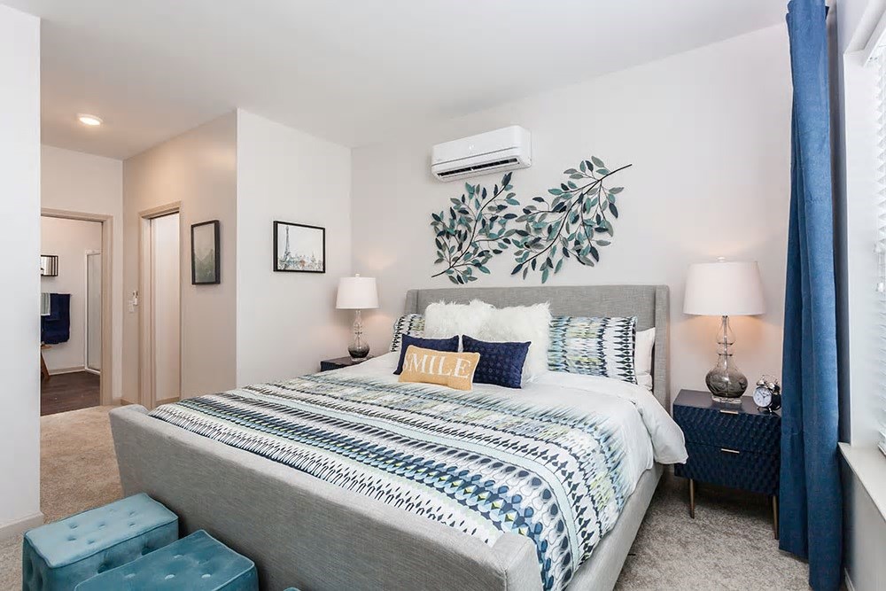 a bedroom with a bed and a plant on the wall