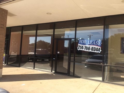 A glass door with a sign that says "FOR LEASE" and a phone number on it.
