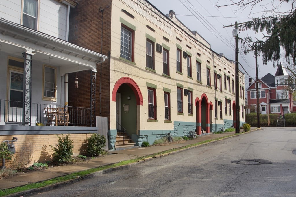 A row of houses with red arched doorways.