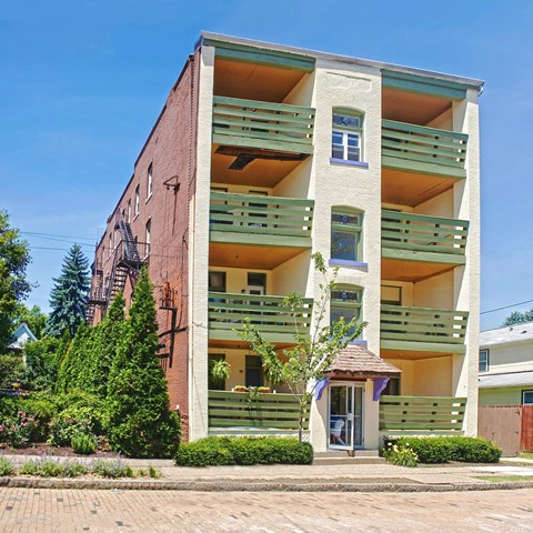 A building with a red brick facade and green balconies.