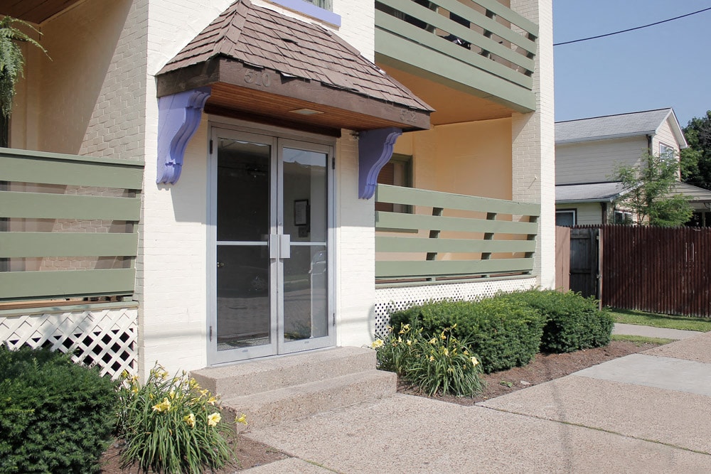 A house with a brown awning over a glass door.
