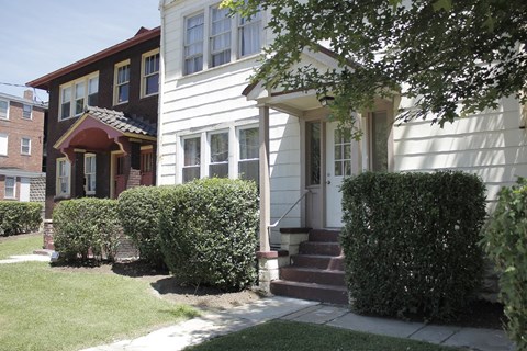 A white house with a red door and a brown house with a white door.