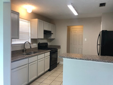 a kitchen with granite counter tops and black appliances