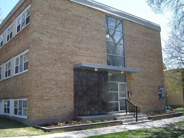 A brick building with a glass door and windows.