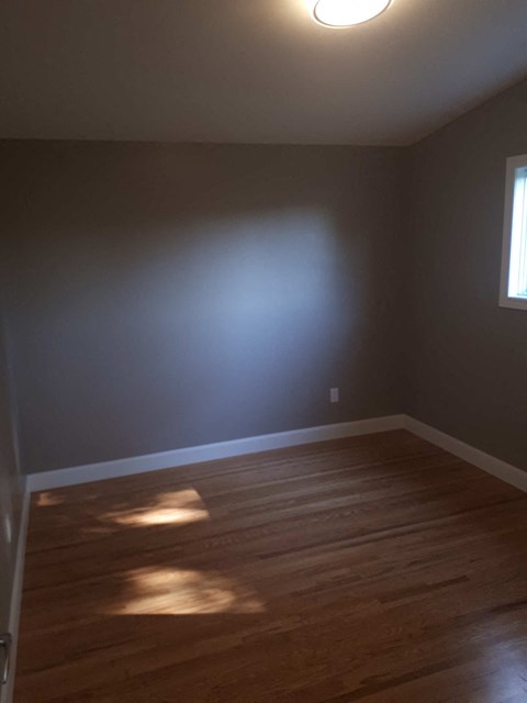 an empty room with wooden floors and a blue wall