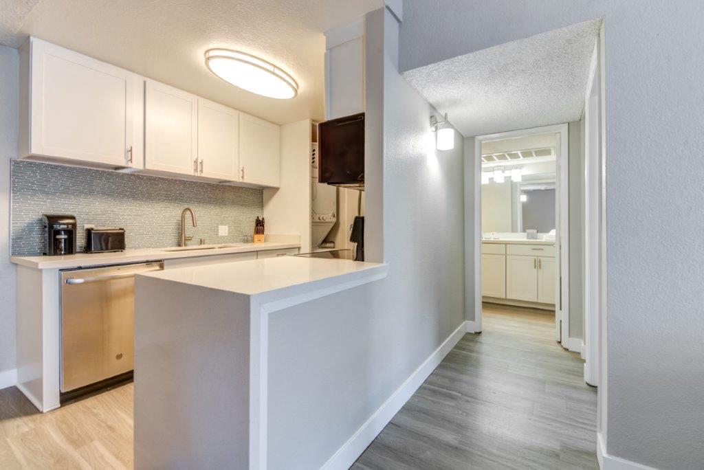 A kitchen with white cabinets and a wooden island.