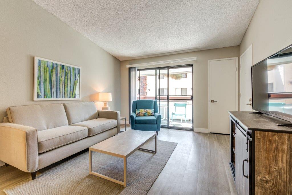 A living room with a couch, chair, and television.