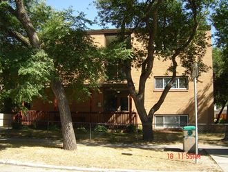 an apartment building with trees in front of it