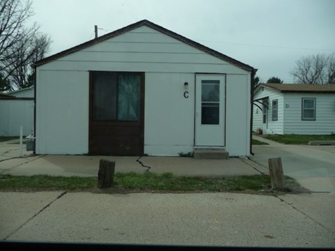 a small white house sitting on the side of a street
