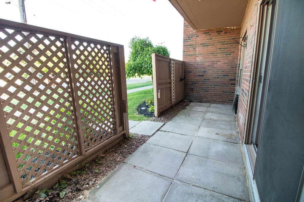 a side yard with a sidewalk and a wooden fence