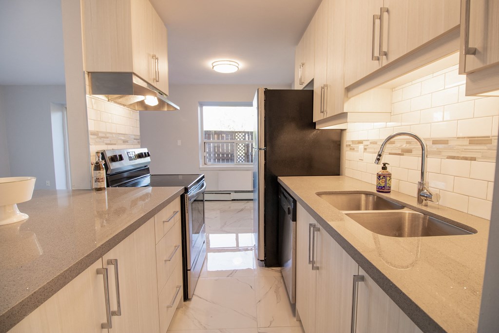 a kitchen with white cabinets and a sink and a refrigerator