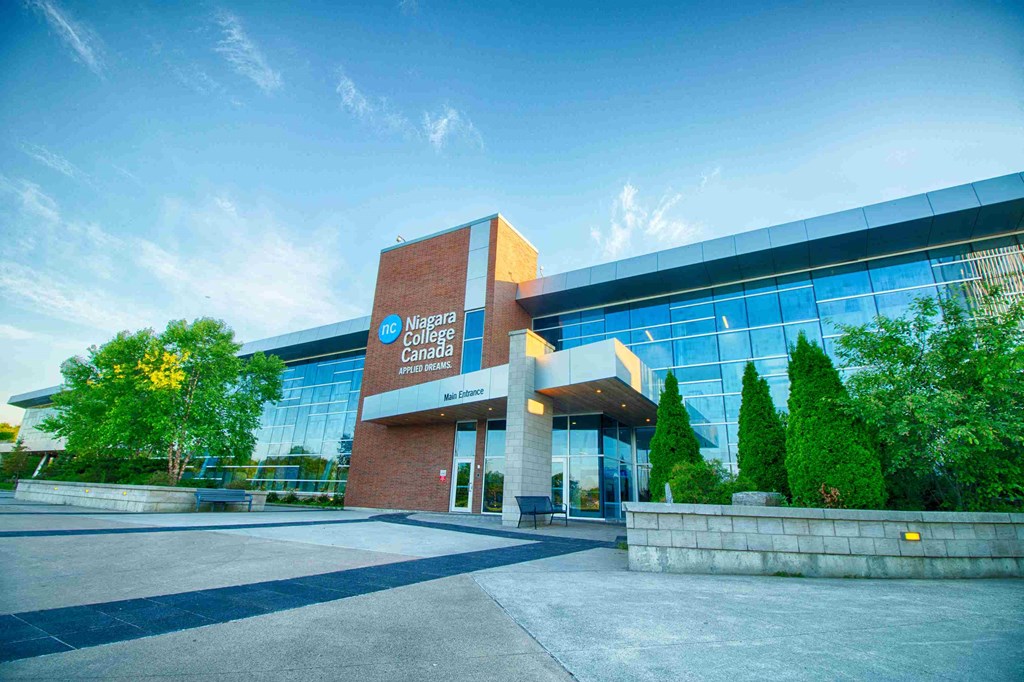 the front of a building with trees and a blue sky