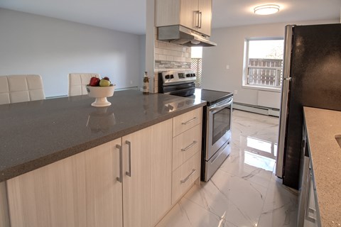 a kitchen with white cabinets and a black counter top