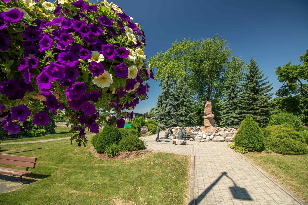 a view of a park with flowers and a statue