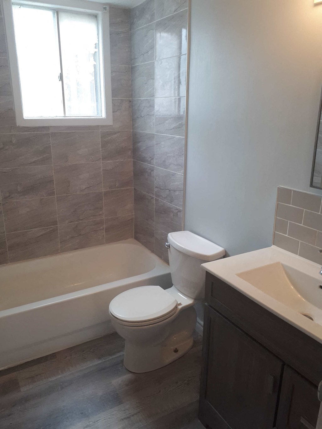 a bathroom with a toilet and a tub and a sink