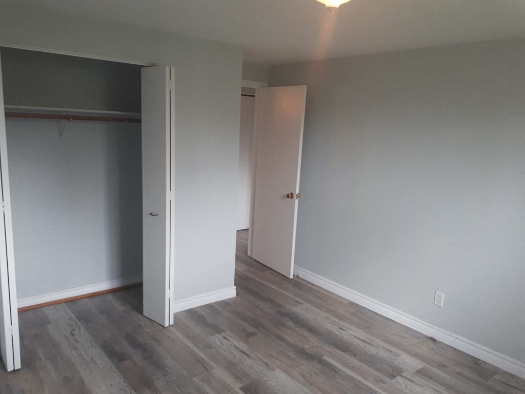 a bedroom with a door open and a closet