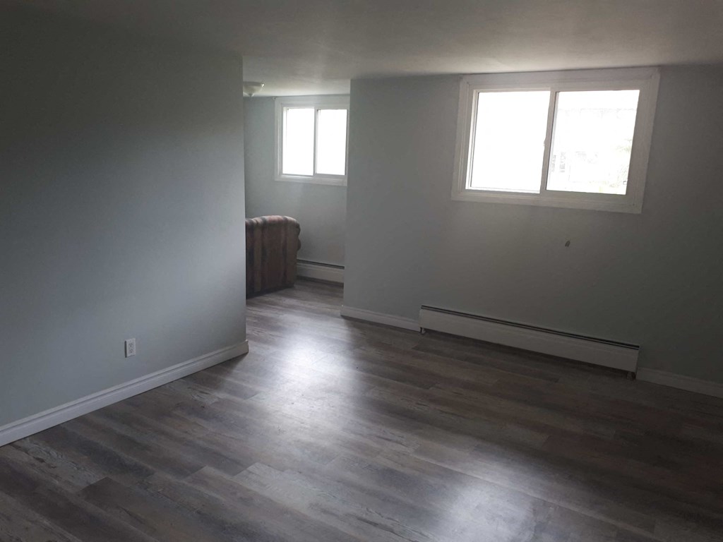 a living room with white walls and wood floors