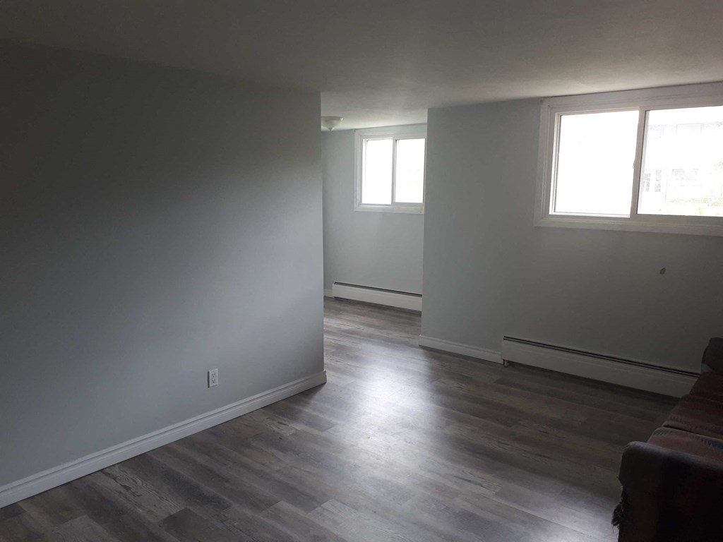 a living room with white walls and wood floors