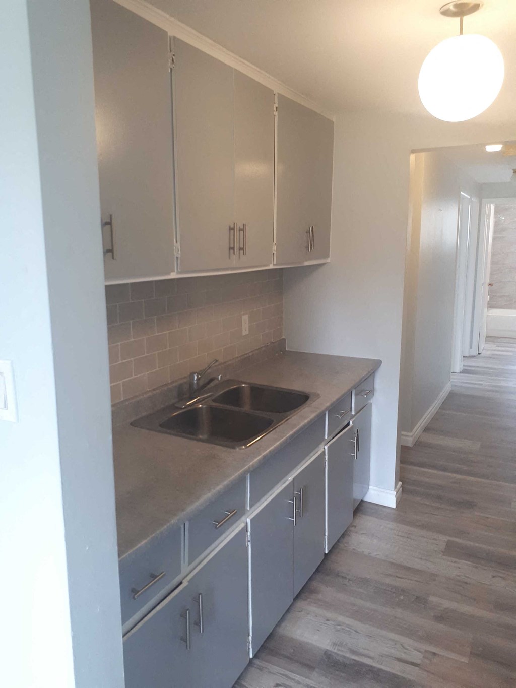 a renovated kitchen with white cabinets and a sink
