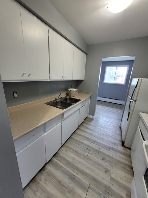 A kitchen with white cabinets and a wooden countertop.