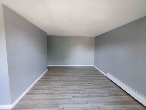 A room with wooden flooring and white walls.