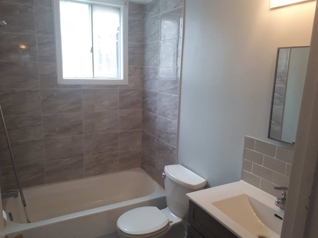 a bathroom with a toilet and a tub and a sink