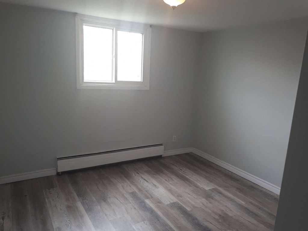a empty room with wooden floors and a window