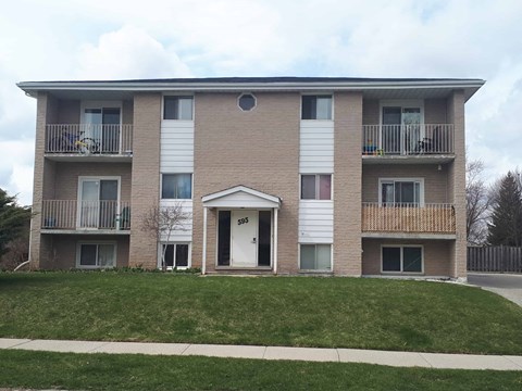 Apartment building with a white door and windows.