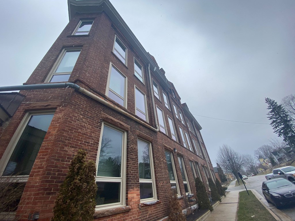 a brick building with windows on the side of a street