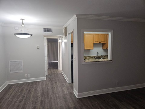 a view of a living room with a large mirror and a hallway to a kitchen