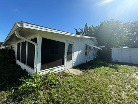a small white house with the front door open