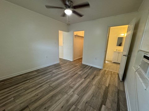 a living room with wood floors and a ceiling fan