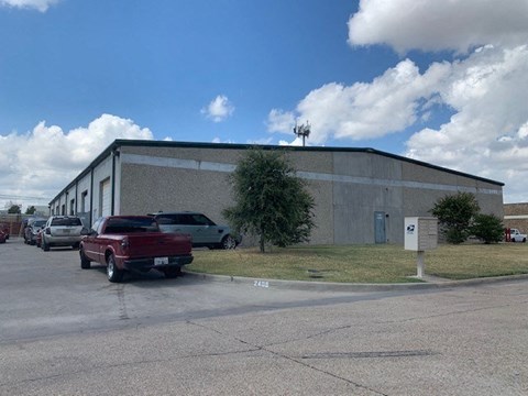 A building with a parking lot in front of it.