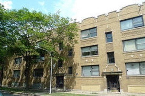 a large brick building with a tree in front of it