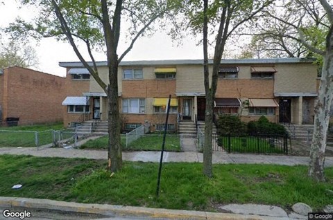 a brick apartment building with trees in front of it