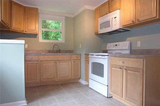 a kitchen with white appliances and wooden cabinets