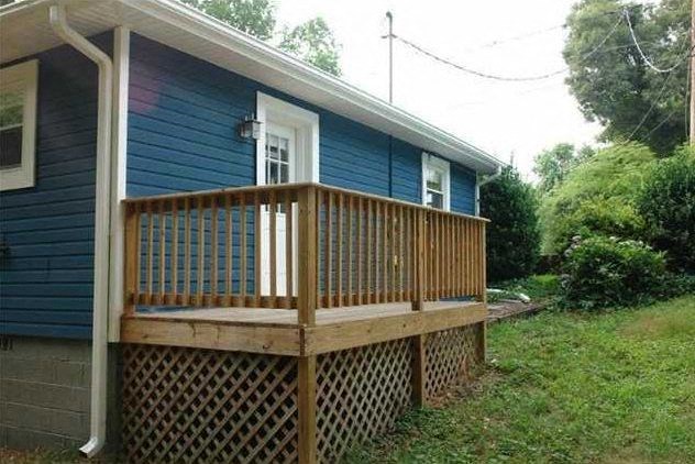 a blue house with a porch with a wooden fence