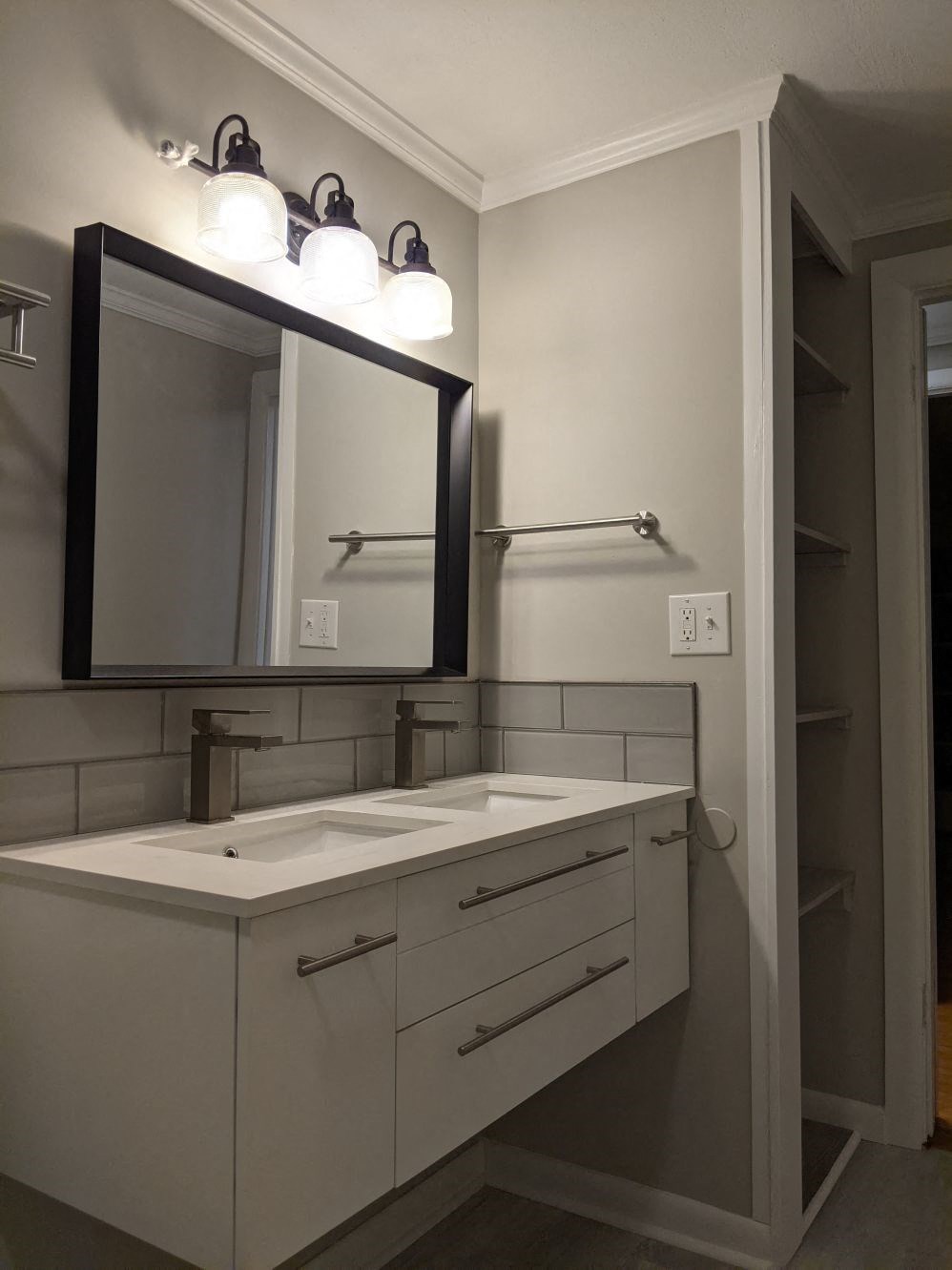 A bathroom with a sink, mirror, and light fixture.