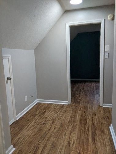 A room with a white door and a brown floor.