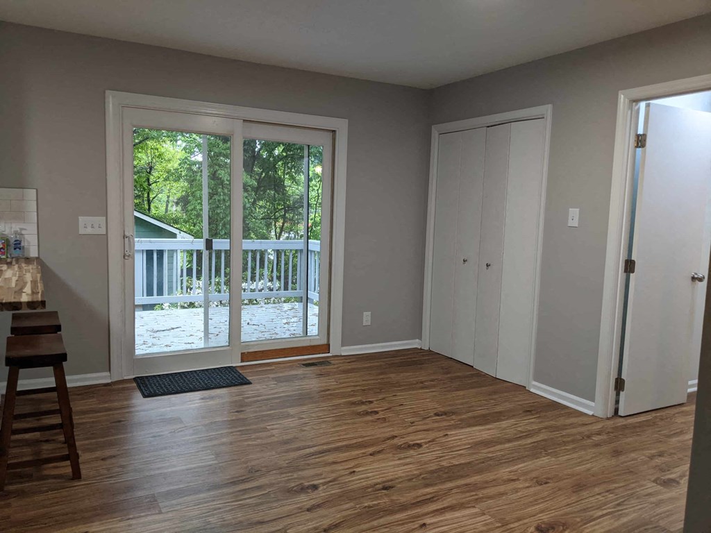 A room with a wooden floor and a white door.