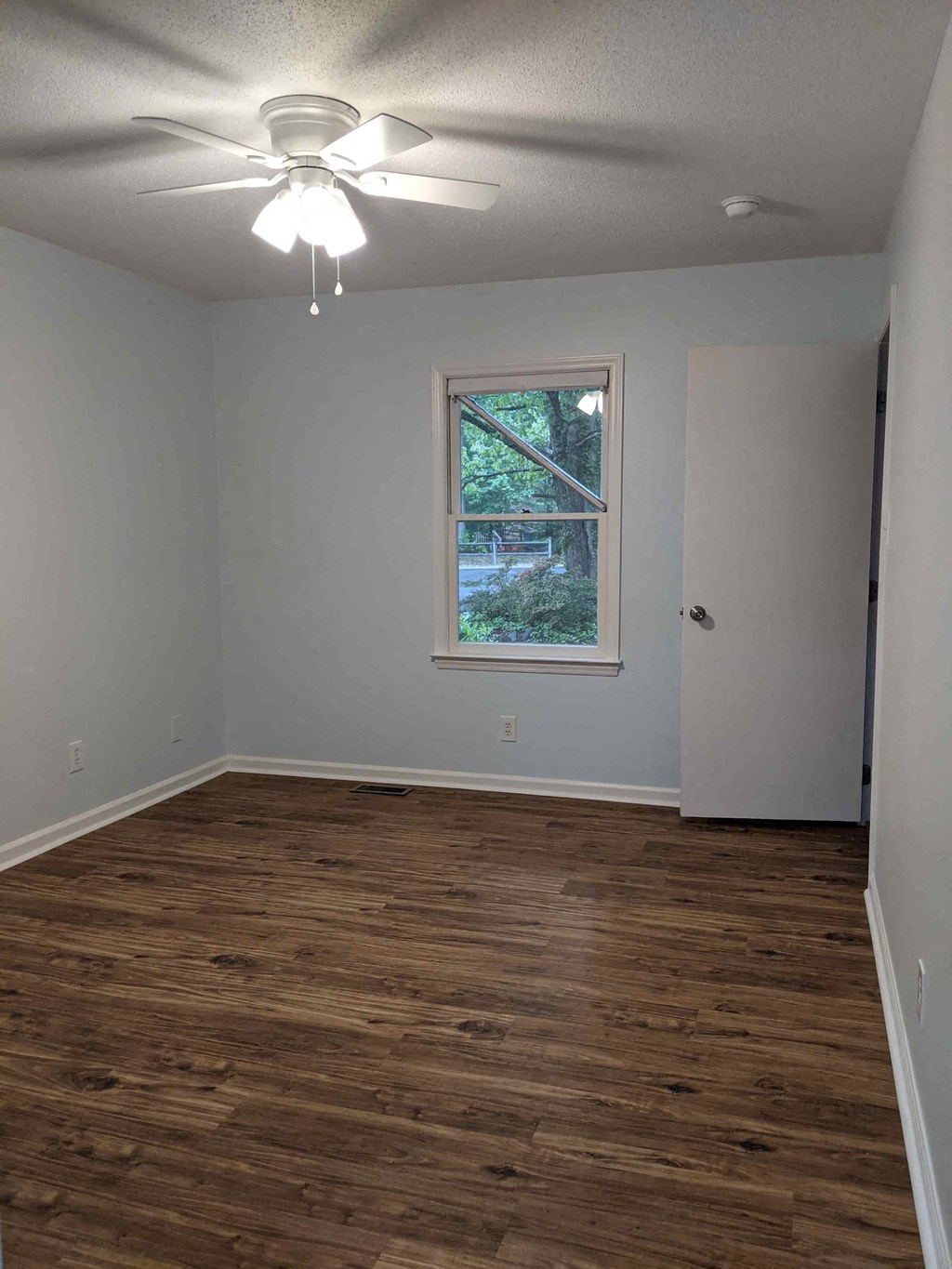 A room with a ceiling fan and a window.