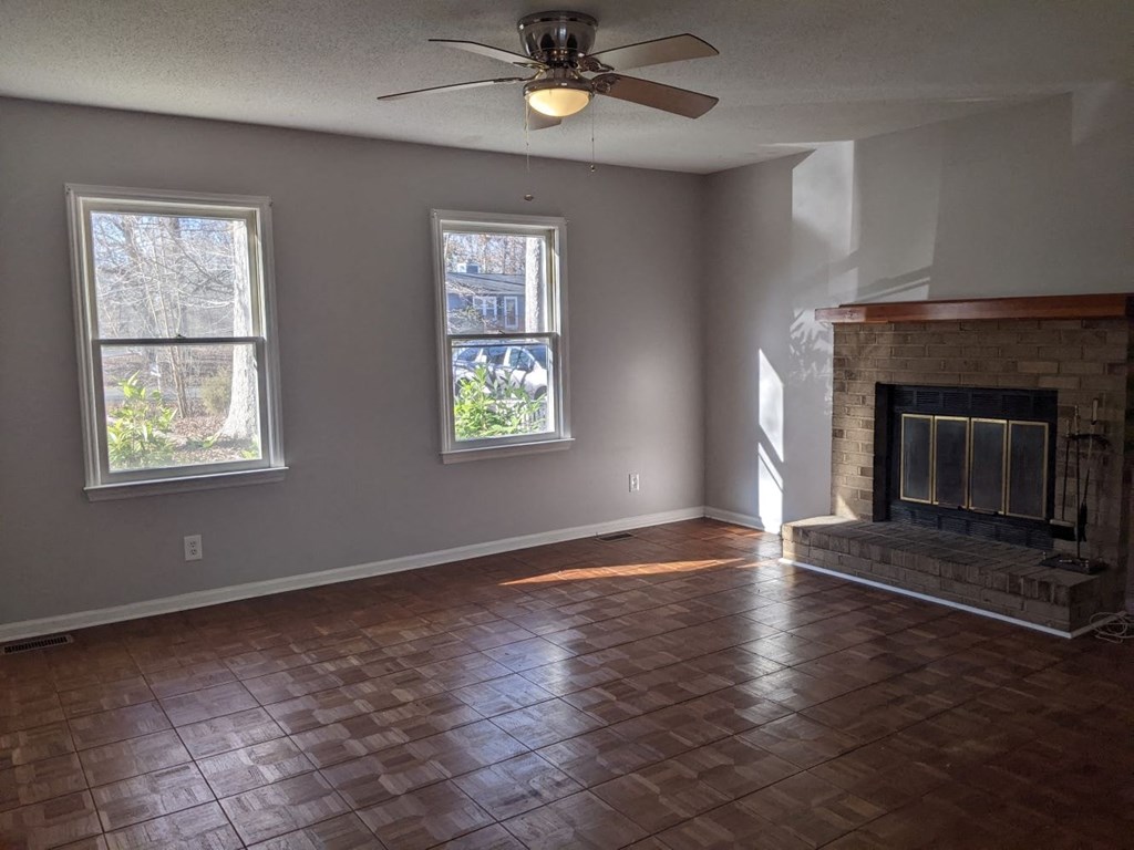 A room with a fireplace and a ceiling fan.