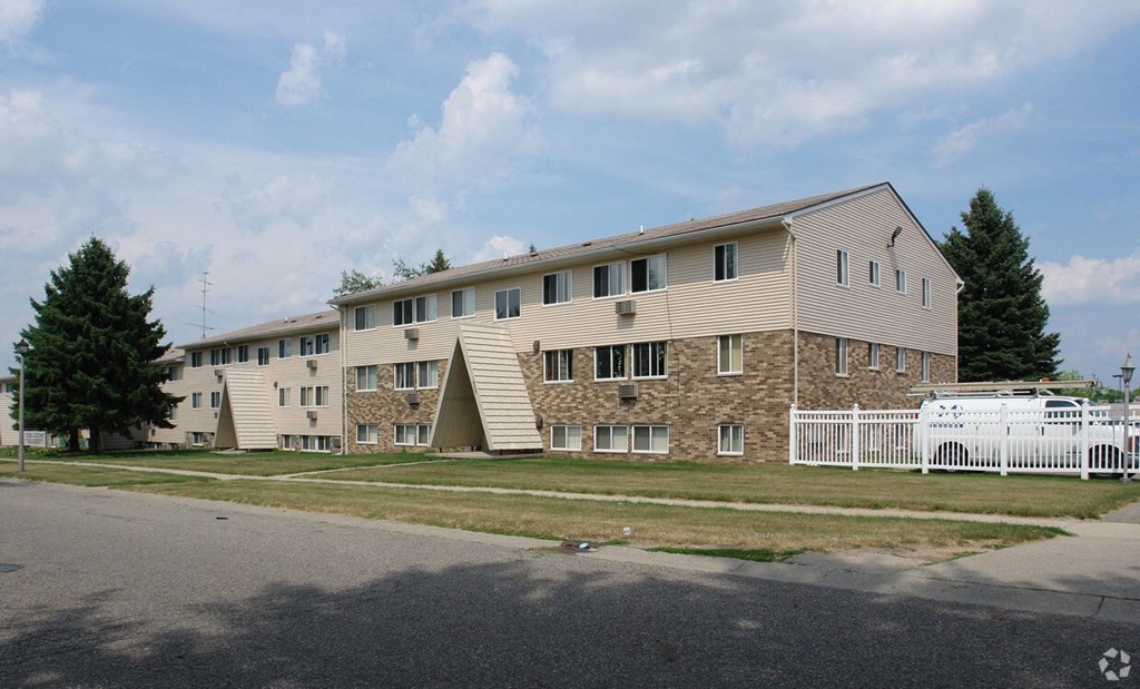 A large building with a white picket fence in front.