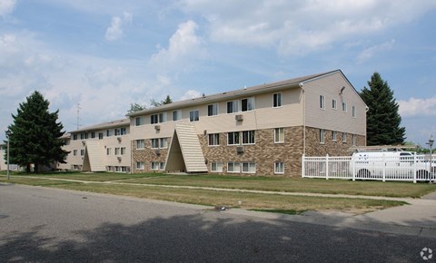 A large building with a white picket fence in front.