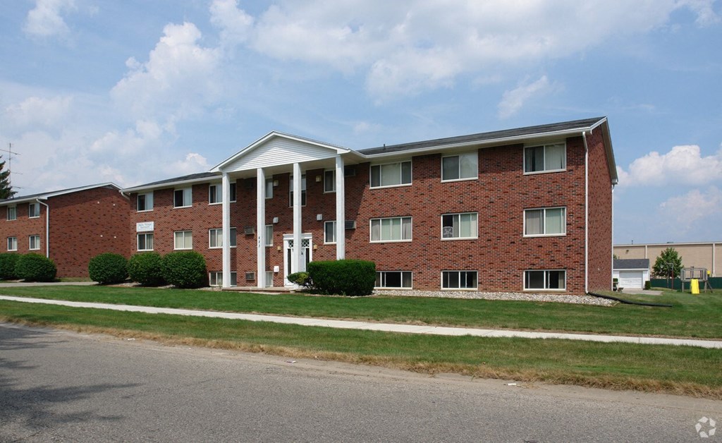 A red brick building with a white roof and columns.