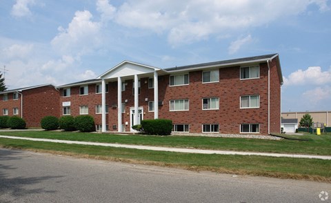 A red brick building with a white roof and columns.