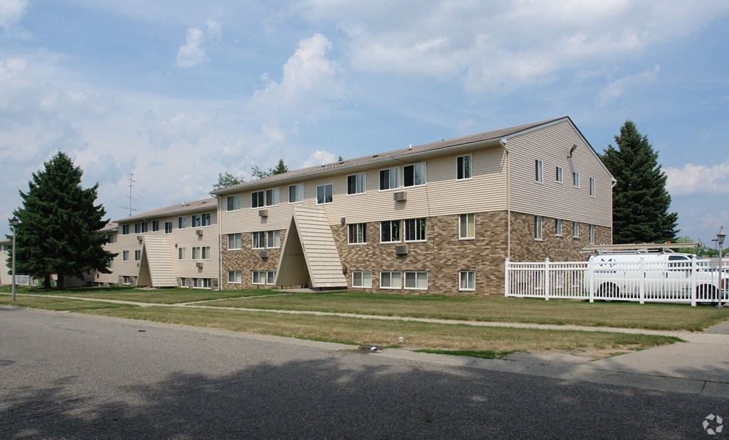 A large building with a white picket fence in front.