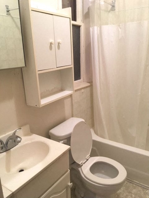 a white bathroom with a toilet and a sink