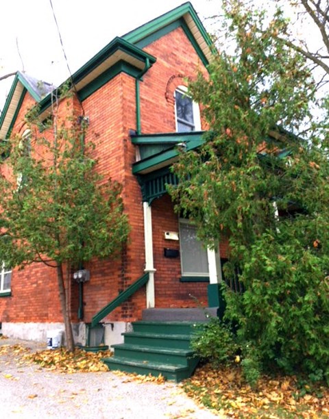 an old red brick house with green stairs