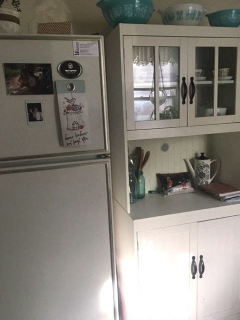 a kitchen with a refrigerator and white cabinets